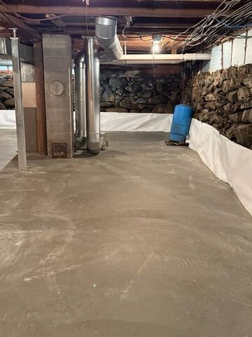 New Concrete Floor - A new concrete basement floor was poured over the prepared drainage system, providing a solid, durable, and significantly improved finished surface.