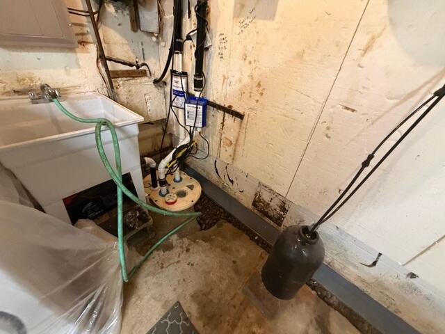 The crew installs a new TripleSafe sump pump to pump out water from the drainage system.