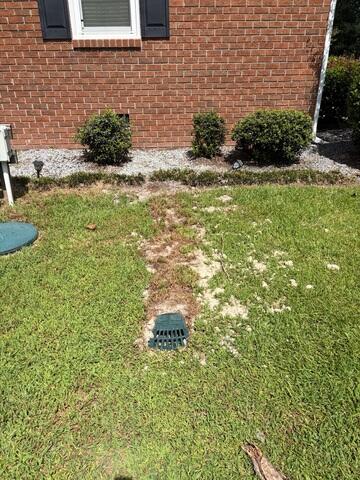 Exterior discharge area where water is pumped out of the crawl space from the sump pump.