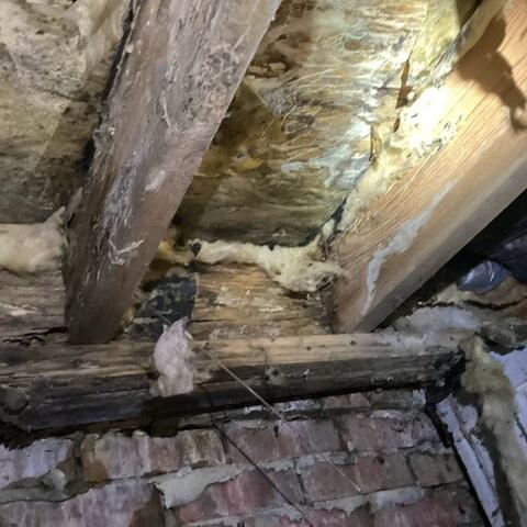 The wood in the subfloor below is old and rotted. The deterioration has caused the floor above to be unstable.