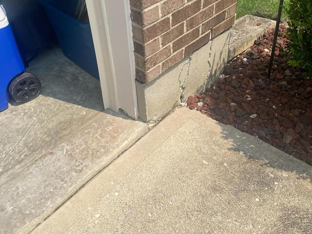 This photo, also taken upon the initial inspection, shows the right side of the garage opening where the driveway meets the garage foundation. This sister crack mirrors the same issue occuring on the left side of the garage door opening.
