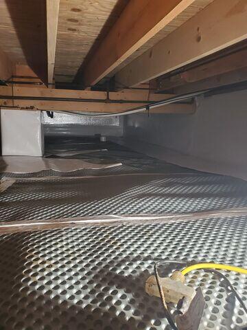 Our crew sealed up the crawl space. First, they installed drainage matting on the floors to help disperse moisture beneath the liner.