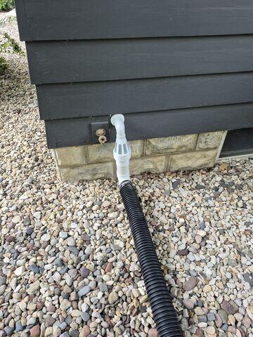 The IceGuard installed at the exterior of the home connecting to the sump pump