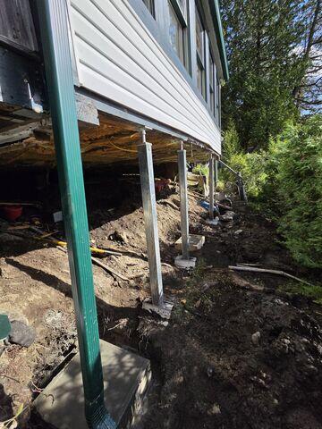 SmartJack System - An engineered crawl space support system with adjustable steel columns beneath the floor structure for permanent stabilization.