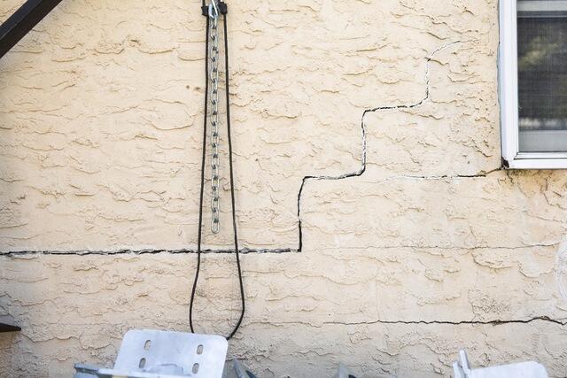 The homeowner was dealing with uneven floors along with cracking around windows and doors, while additional cracking was visible across the lower-level floor. When several areas of a home show signs of movement, evaluating the support beneath the structure can help determine what is contributing to the changes.