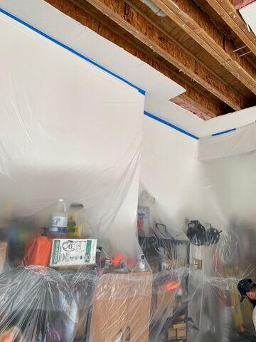 During: Protective plastic containment installed throughout the garage to help protect stored belongings and surrounding surfaces during the repair.