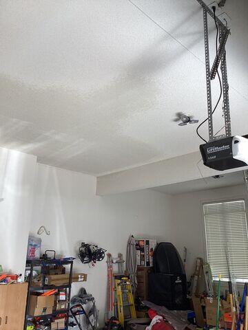 After: Wide view of the completed garage ceiling repair, with the patched areas blended into the existing popcorn texture and left ready for paint.