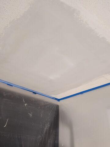 Ceiling repair in progress after the damaged areas were patched and prepared for new popcorn texture.