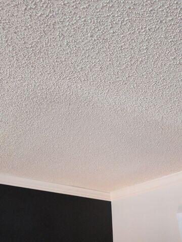 Finished popcorn ceiling repair showing the patched areas retextured and blended into the surrounding ceiling.