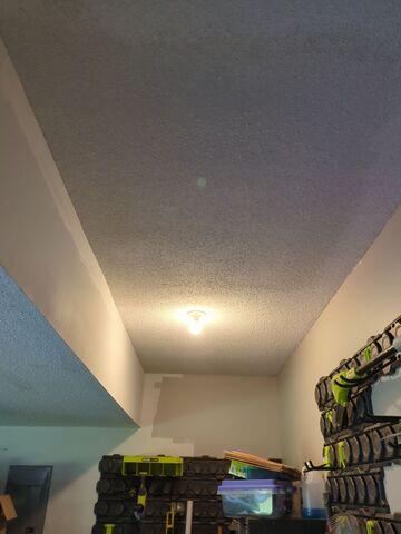 Completed garage ceiling repair in Olathe, KS with new popcorn texture blended across the repaired section.