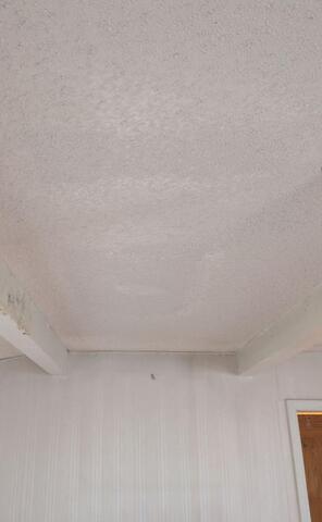 Finished and painted ceiling with the repair blended into the surrounding popcorn texture.