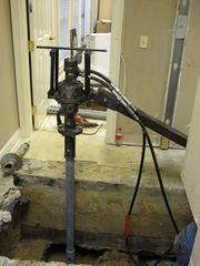 Interior helical pile installed with hand equipment