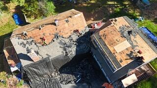 In this photo, the crew has stripped away the old shingles and underlayment, leaving the decking exposed. This crucial step allows us to thoroughly inspect the structure and ensure the roof is in good condition before applying the new layers. Any damaged decking will be replaced, providing a strong, solid foundation for the new roof system.