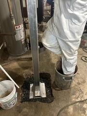 Heavy-duty steel SmartJack posts were then precisely cut to fit the height of the basement and positioned beneath the compromised beams.