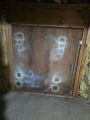 The door from the crawl space to the space underneath the three-season room, prior to our work.