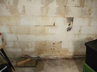 This wall shows evidence of water intrusion and bowing. A permanent solution was designed exclusively for this home to eliminate further water intrusion as well as assistance in securing the bowing wall.