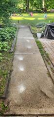 This photo shows the settled concrete around a homeowner's property in Freeport, IL, creating dangerous trip hazards and an uneven surface.