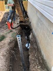In this photo, our crew is installing Helical Piers after completing the excavation around the foundation in Chantilly, VA. These deep foundation supports are drilled into stable soil to permanently stabilize and lift the structure. Helical Piers are a trusted solution for homes experiencing settlement and sinking foundations.