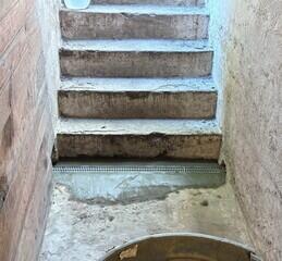 The TrenchDrain grated basement drain is installed at the base of the bulkhead stairs to collect surface and excess water.