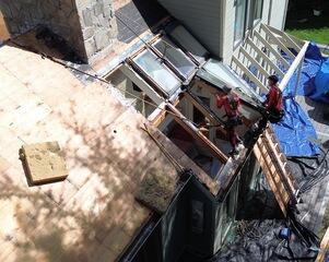 Here, the eight skylights are being taken out, and the plywood decking is exposed around it from the roof replacement taking place. This step is necessary to reconfigure the layout and address ongoing leak concerns around the skylight section.