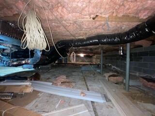 Moisture seeped through the dirt floor and walls, leaving the crawl space musty and damp.
