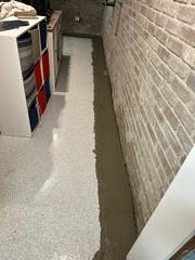 The crew installed WaterGuard to capture water at the wall-floor joint and direct it to the sump pump, keeping the basement permanently dry.