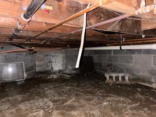 The crawl space was unprotected, with bare walls and no insulation, allowing moisture and outside air to seep in.