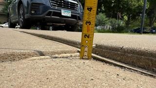 A close up of how far the concrete slab on the driveway began sinking