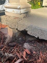 A close up of the porch where soil washout is present
