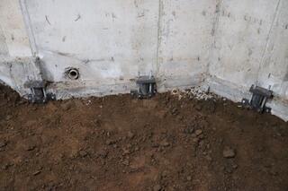 The soil is then put back to cover the holes and a vapor barrier covers the soil. This homes foundation is now secured.