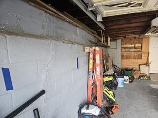 The bowing and cracking walls in this homeowner's garage were caused by excessive lateral pressure from expanding soil and poor drainage. Over time, this pressure forced the foundation walls inward, leading to structural stress and visible damage.