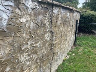 Large vertical cracks had formed in the retaining wall, showing clear signs of structural stress and outward movement caused by soil pressure.