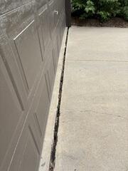 The gap that had formed between the driveway and garage