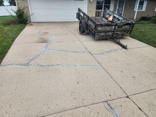 This photo taken upon the initial inspection shows the various cracks spanning the driveway. The homeowner tried to seal it themselves with a big box store - urethane based sealant, which failed in less than 2 years.