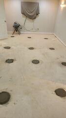 This photo shows the same room with the piers concealed with a fresh concrete backfill.