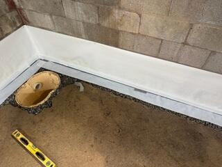 This photo shows where we dug a hole to make room for our sump pit. We also covered the top of our drains with our moisture proof tape to prevent moisture transference.