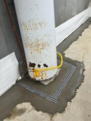 This was where we encased the base of the water heater with a trench drain system. If this water heater ever leaks, the water will be captured by the drainage system.