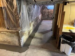 WaterGuard perimeter drain completed along the foundation wall, concealed beneath fresh concrete. A little bit of the wall flange is left exposed above the floor to be able to transfer wall leaks into the system.