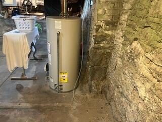 Moisture marks along the wall cove observed during the initial inspection, confirming where water was entering through the stone foundation. We moved this water heater away from the wall before installing as well.