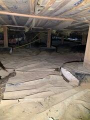 The vapor barrier around the footing of the wooden posts was ripped and caused water to enter. There was rodent droppings and urine all over the old barrier causing the home to smell.