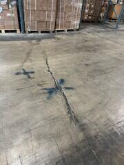 Slab cracking and spalling in warehouse area.