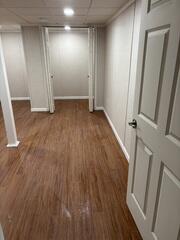 Another view of the finished basement highlighting the open layout and cohesive design. The newly installed flooring and trim bring a polished, complete look throughout the space.
