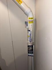 The PVC pipe that connects to the footing of the home and to the fan