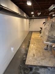 The completed WaterGuard system sealed with fresh concrete, and CleanSpace vapor barrier installed along the walls for a clean, waterproof finish.