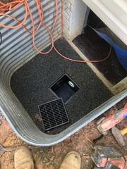 Window well with new drainage system in the process of being installed.