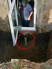 This close up shows the drain tie-in we hooked up to the existing footer drains. We then filled the base of the well up with gravel to make the gravel floor flush with the top of the drain. The drain was capped with a grate to prevent debris from entering.