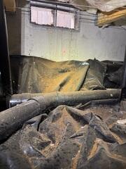 The open vents in this crawl space brought in water, pests and a lot of debris causing the old barrier to be very dirty.