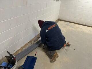 Our crew installing WaterGuard along the entire perimeter, opening a clean trench at the footing to prepare the drainage system.