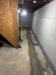 The DryTrak Drainage System was installed to capture and redirect groundwater away from the basement, preventing water from seeping into the home.
