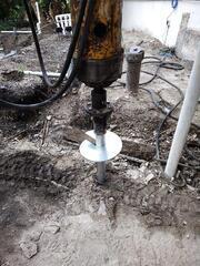 Installing helical piles around buried utilities.